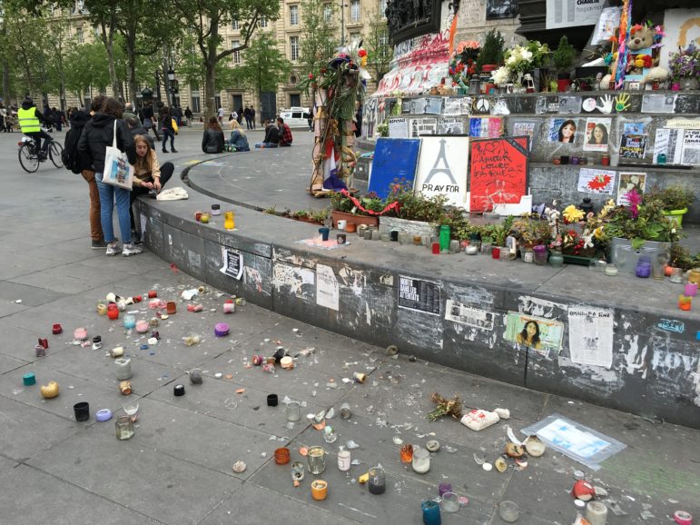 Billedet viser minderne for de faldne for terroraktioner i Paris. Venner og familier til ofrene for angrebet på Charlie Hebdo, Bataclan og Stade de France benyttede statuen på Place de la République som et sted for ærbødighed og hyldest til de døde. Den 1. august 2016 fjernede bystyret alle billeder, lys og glas. Foto: Nils Mulvad.